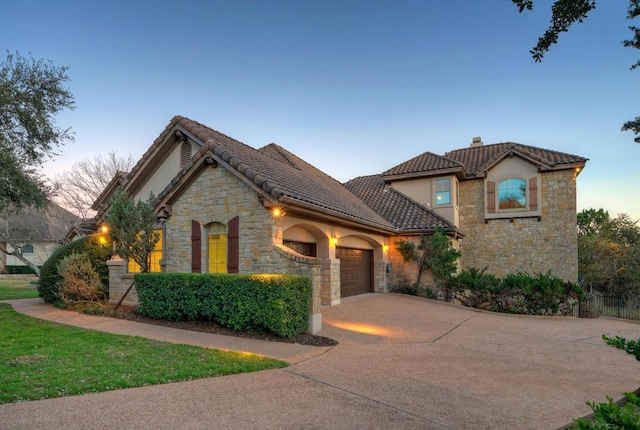 view of front of home featuring a tile roof, driveway, an attached garage, and stucco siding