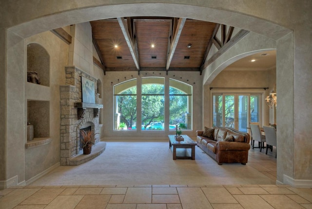 unfurnished living room featuring high vaulted ceiling, a stone fireplace, beam ceiling, and wood ceiling