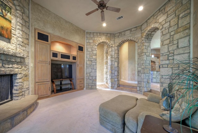 carpeted living area with arched walkways, a fireplace, recessed lighting, visible vents, and ceiling fan