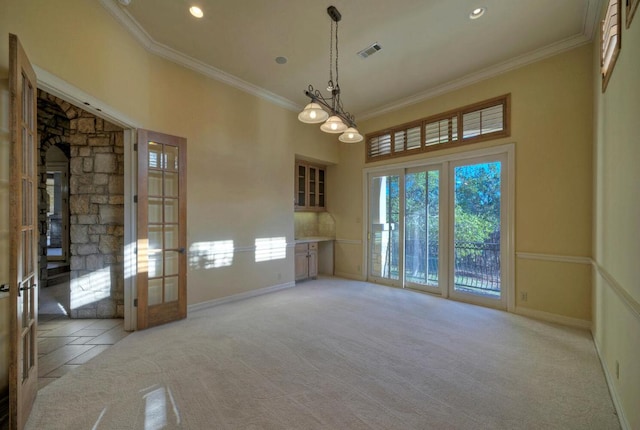 empty room with ornamental molding, french doors, light carpet, and a high ceiling