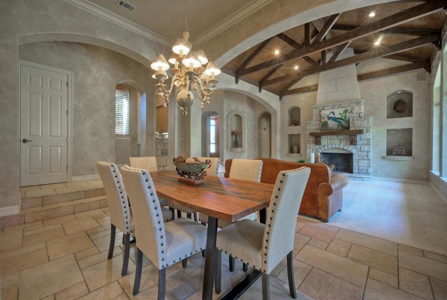 dining area with stone tile floors, baseboards, visible vents, a stone fireplace, and beam ceiling