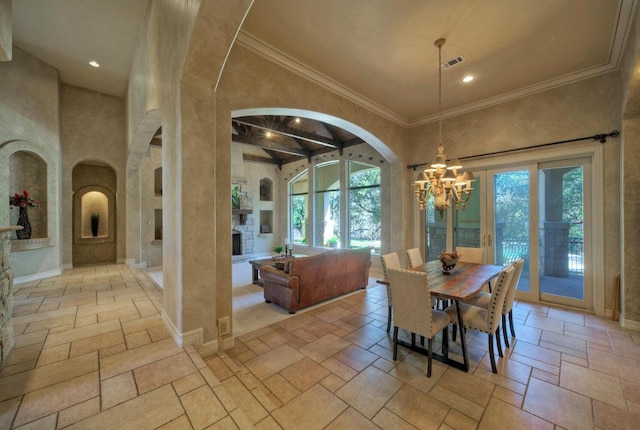 dining area featuring a healthy amount of sunlight, stone tile floors, a fireplace, and a high ceiling