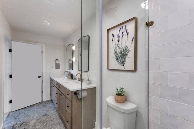 bathroom with a sink, toilet, and double vanity