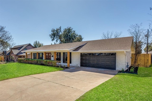 ranch-style home with driveway, an attached garage, fence, and a front yard