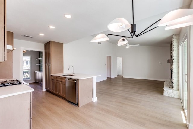 kitchen featuring visible vents, dishwasher, open floor plan, light countertops, and a sink