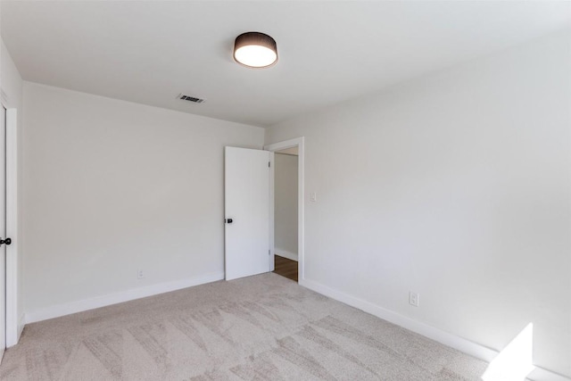 spare room featuring carpet flooring, visible vents, and baseboards