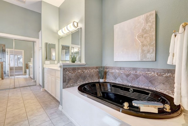 full bath with a garden tub, vanity, and tile patterned floors