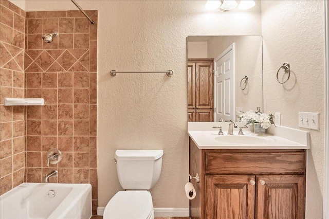 bathroom featuring toilet, shower / bath combination, a textured wall, and vanity