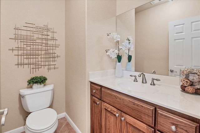 bathroom featuring tile patterned flooring, baseboards, vanity, and toilet