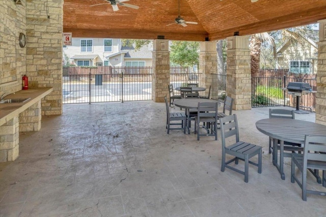 view of patio / terrace with a grill, fence, a ceiling fan, and outdoor dining space