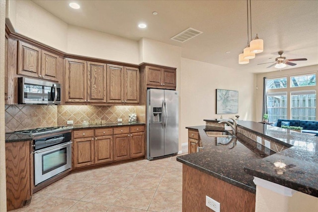 kitchen with visible vents, appliances with stainless steel finishes, a sink, pendant lighting, and backsplash