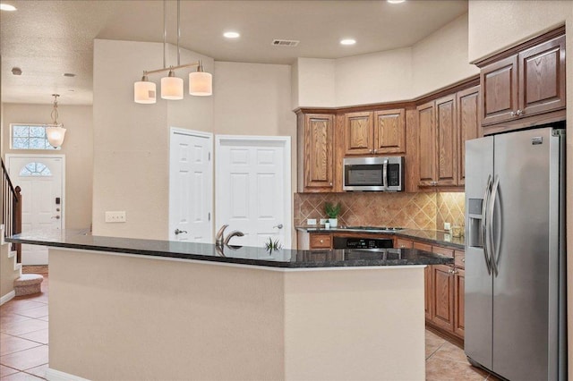 kitchen with light tile patterned floors, appliances with stainless steel finishes, visible vents, and decorative backsplash