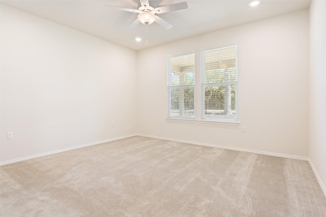 spare room with light carpet, recessed lighting, a ceiling fan, and baseboards