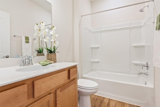 bathroom with shower / bathtub combination, vanity, wood finished floors, and toilet