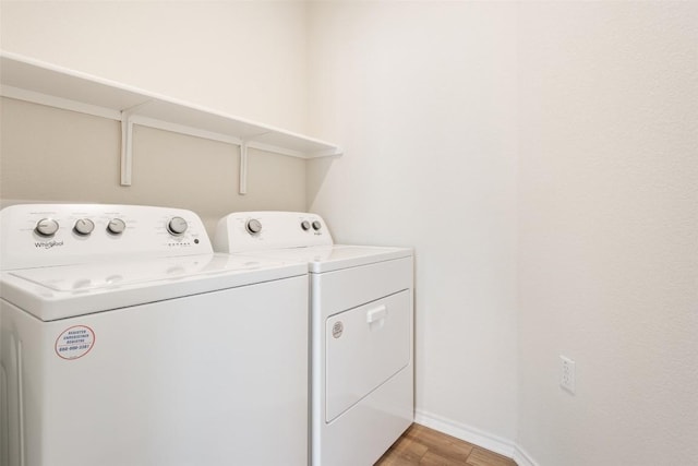 laundry area with baseboards, laundry area, washer and clothes dryer, and light wood-style floors