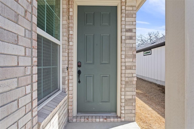 entrance to property featuring brick siding