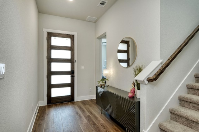 entryway with baseboards, wood-type flooring, stairs, and visible vents