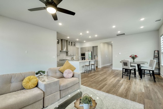 living area with light wood-type flooring, recessed lighting, a ceiling fan, and visible vents