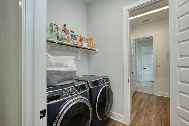 laundry area featuring baseboards, washer and clothes dryer, laundry area, and wood finished floors