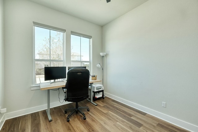 office area featuring baseboards, wood finished floors, and a wealth of natural light
