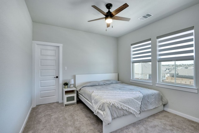 carpeted bedroom with visible vents, baseboards, and ceiling fan
