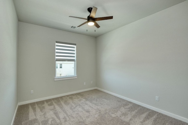carpeted empty room featuring baseboards, ceiling fan, and visible vents
