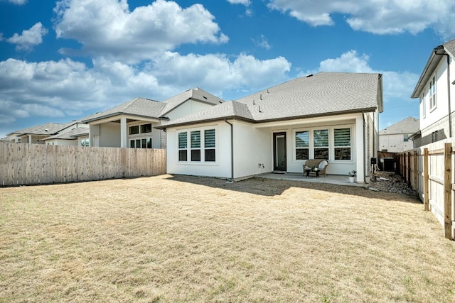 rear view of house with a yard, a patio, a fenced backyard, and stucco siding