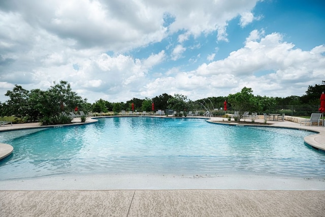 community pool with fence and a patio area