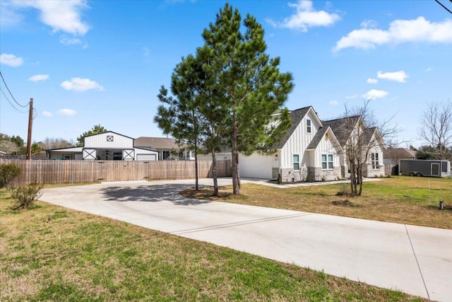 view of yard with driveway, a garage, and fence