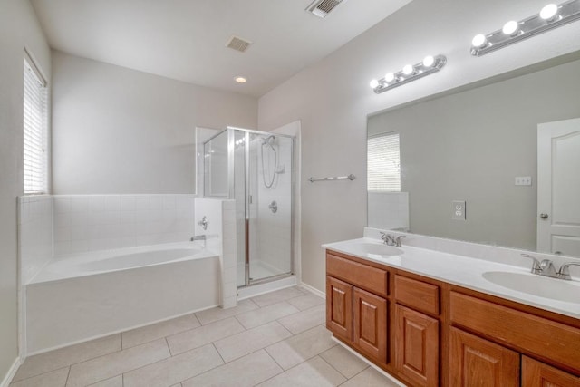 bathroom featuring a bath, double vanity, a sink, and visible vents