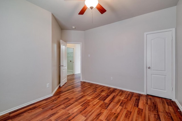 unfurnished room with a ceiling fan, baseboards, and wood finished floors