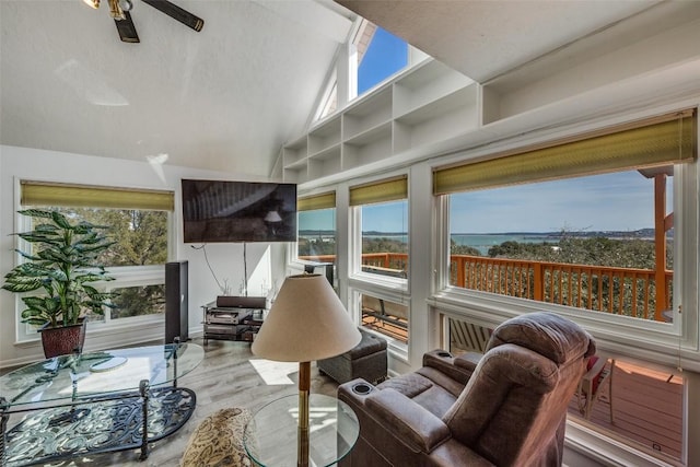 sunroom with ceiling fan and vaulted ceiling