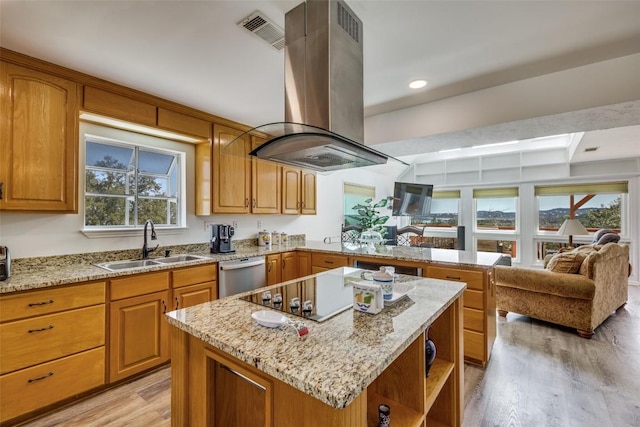 kitchen featuring visible vents, island range hood, dishwasher, a peninsula, and a sink