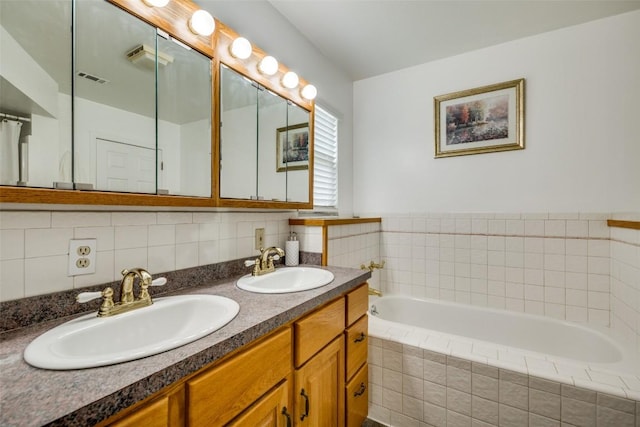 bathroom with double vanity, visible vents, a sink, and a bath