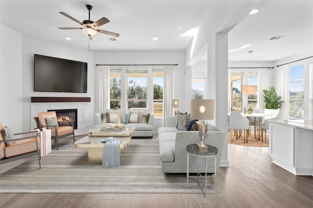 living area with a fireplace, wood finished floors, visible vents, and recessed lighting