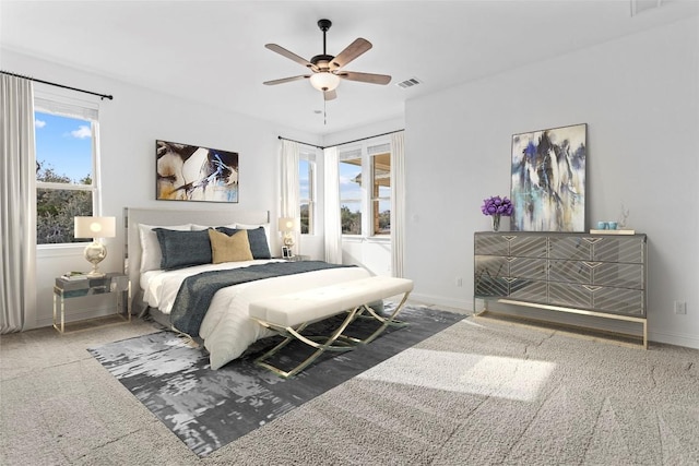 bedroom featuring carpet floors, multiple windows, visible vents, and baseboards