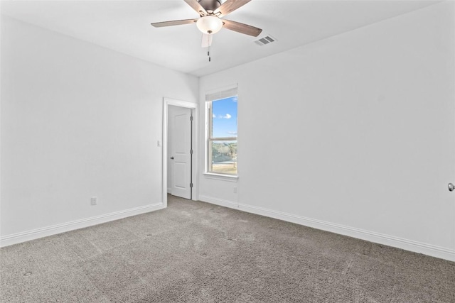 spare room with a ceiling fan, visible vents, baseboards, and carpet flooring