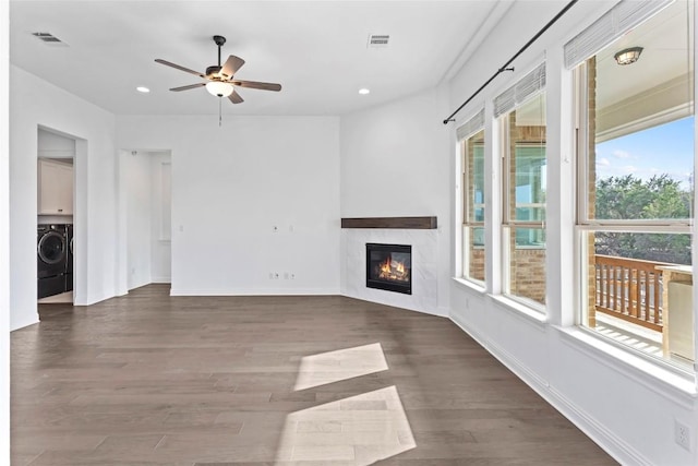 unfurnished living room featuring visible vents, a fireplace, wood finished floors, and washer / dryer