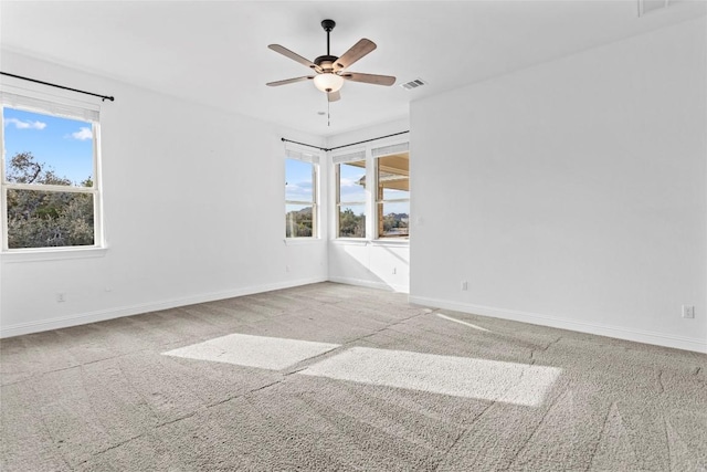 unfurnished room with carpet floors, a healthy amount of sunlight, and visible vents