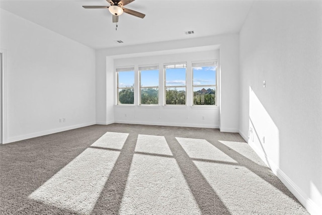 empty room with baseboards, visible vents, and carpet flooring