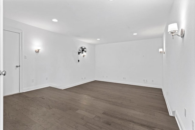 spare room with dark wood-type flooring, recessed lighting, and baseboards