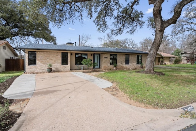 ranch-style house with a front yard, fence, and brick siding