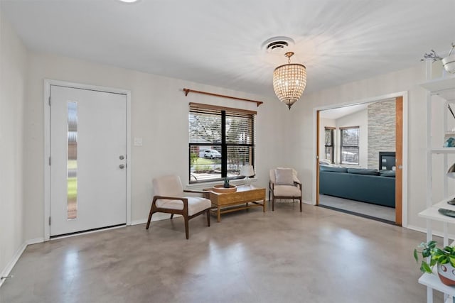 living area featuring baseboards, visible vents, concrete floors, and a chandelier