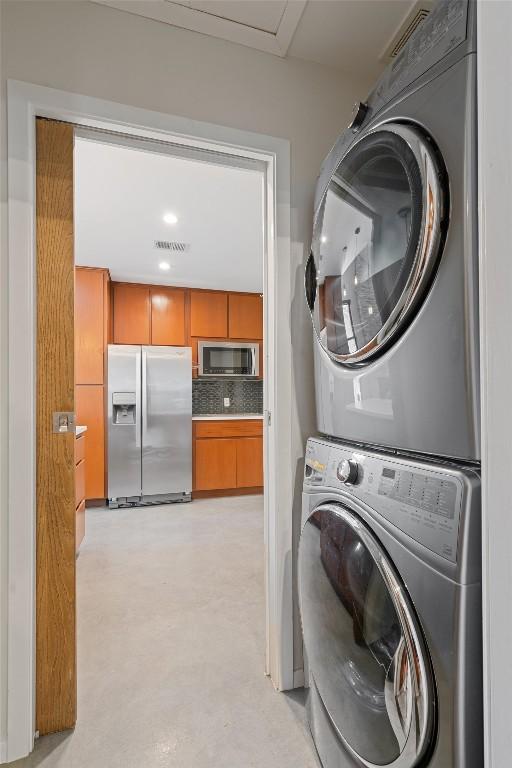 laundry area featuring laundry area, stacked washer / dryer, and visible vents