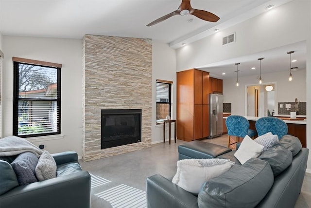 living area with a ceiling fan, finished concrete flooring, visible vents, recessed lighting, and a large fireplace