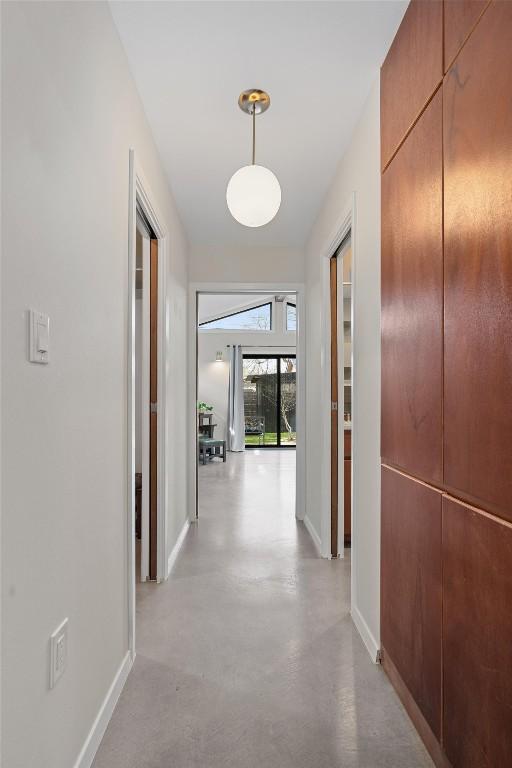 hall with concrete floors and baseboards