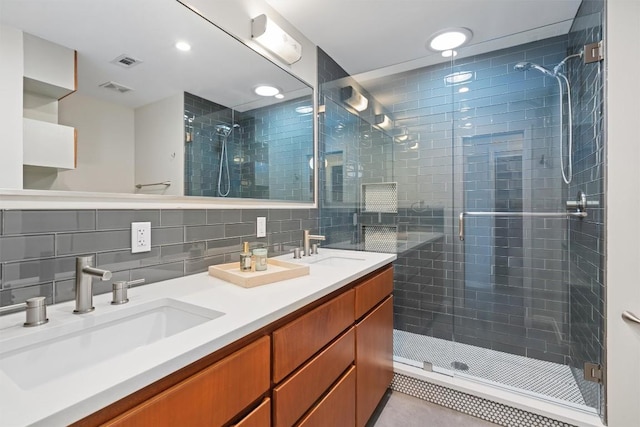 bathroom with a stall shower, visible vents, and a sink