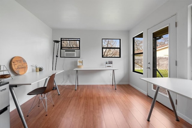 office space featuring light wood-type flooring, baseboards, and cooling unit