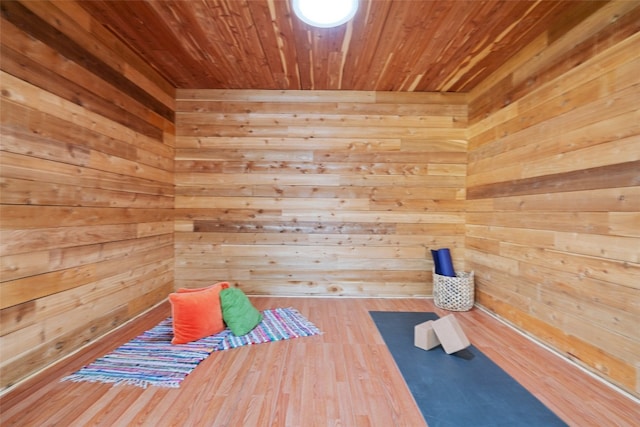 workout area featuring wooden walls, a sauna, wood ceiling, and wood finished floors