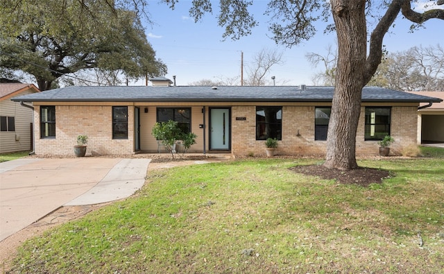 ranch-style house featuring brick siding, a front yard, and a shingled roof